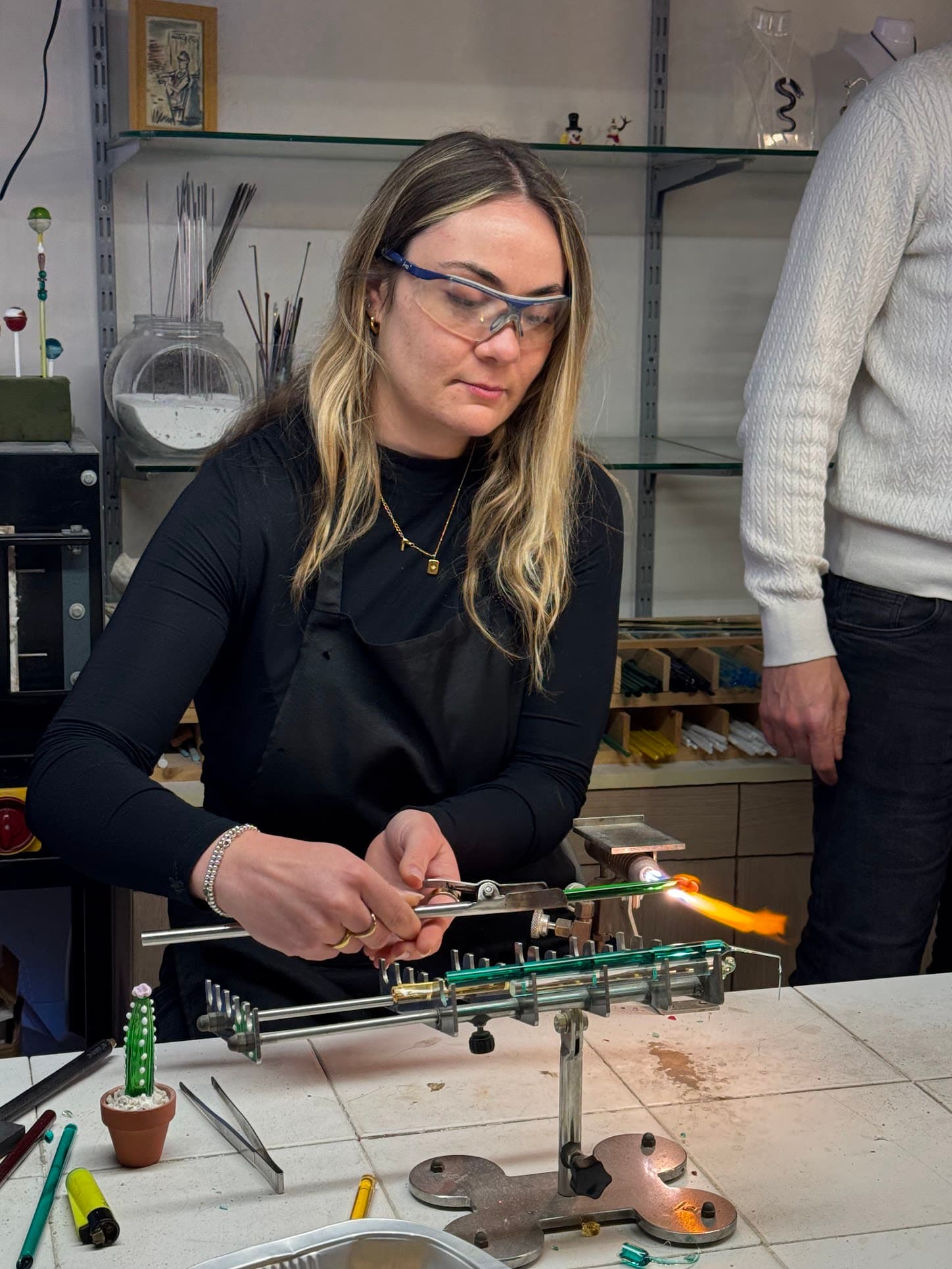 Ellie at the glassmaking workshop working with a flame